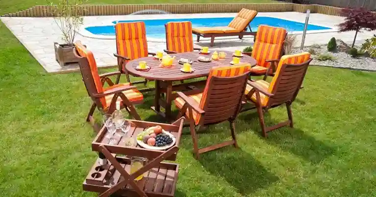 Complete set goedkope tuinmeubelen van hout bij een zwembad