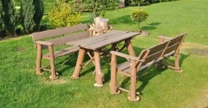 Rustieke houten tuinmeubelset met een tafel en twee banken op een groen gazon